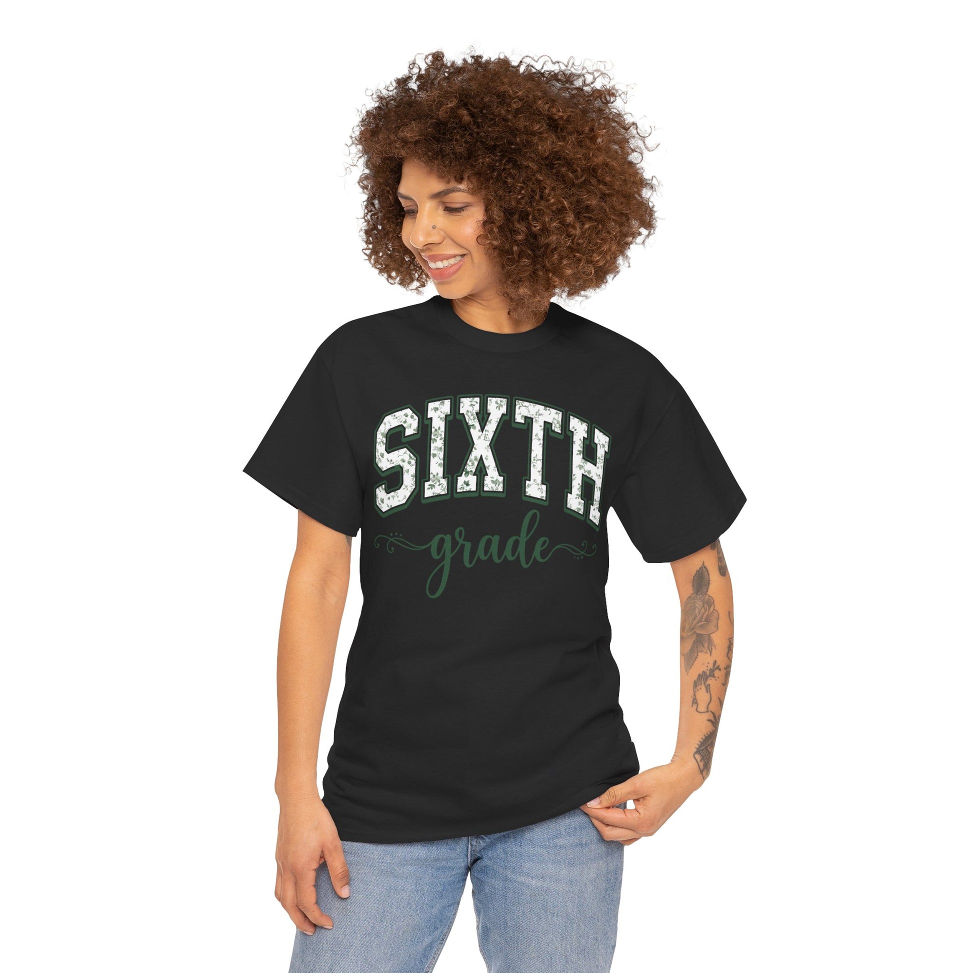 Woman wearing a black t-shirt with 'SIXTH grade' text on a white background. Floral sixth grade tee from TEEZOCA reading sixth grade in arched varsity type, a unisex adult shirt for school staff.
