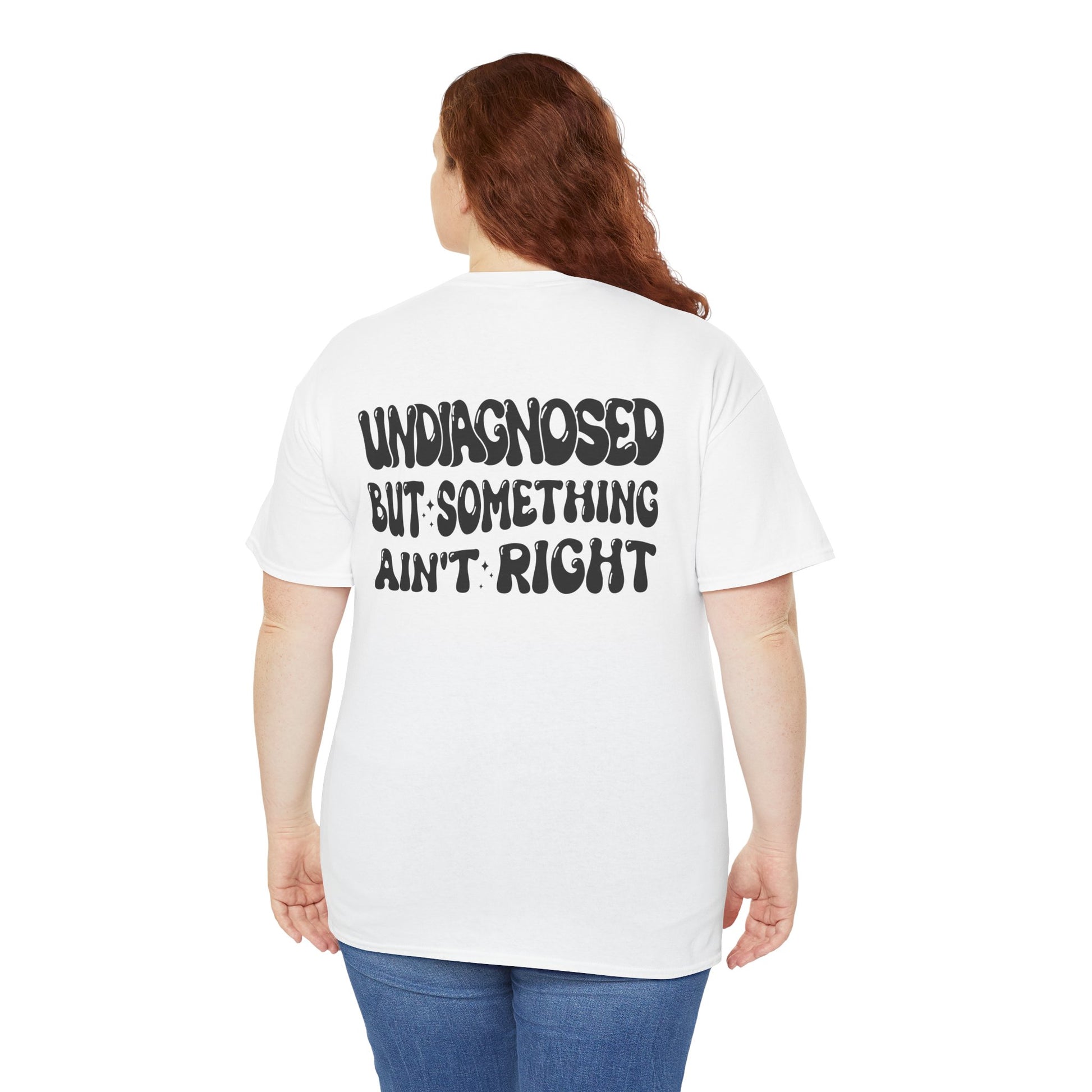 Women wearing  a Back Print of a white T-shirt featuring the viral meme phrase "Undiagnosed But Something Ain't Right" in bold wavy retro typography, a trending funny mental health meme shirt, unhinged humor tee, therapy meme graphic, and relatable back print statement design.
