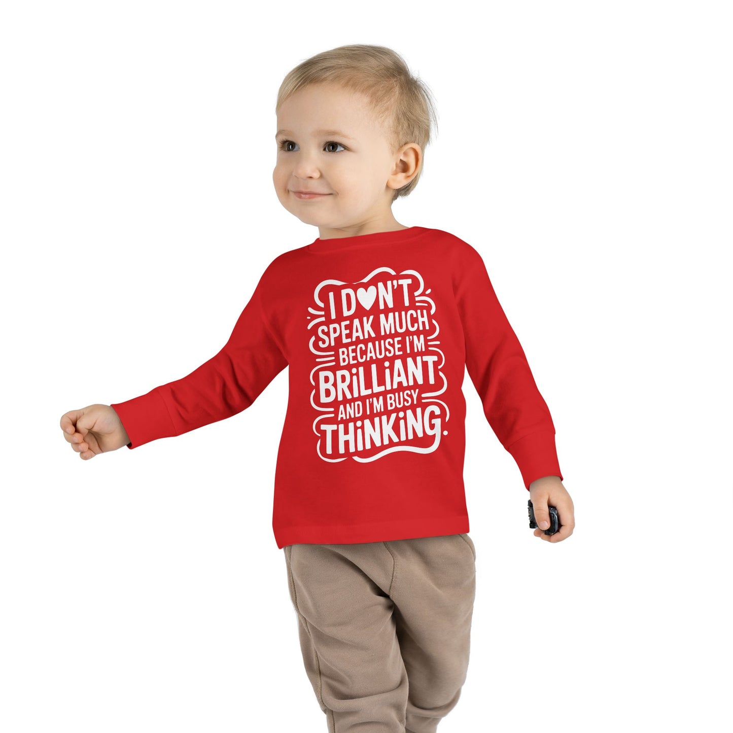 Toddler walking in red autism awareness long sleeve shirt with “I don’t speak much because I’m brilliant and I’m busy thinking” text, side pose.