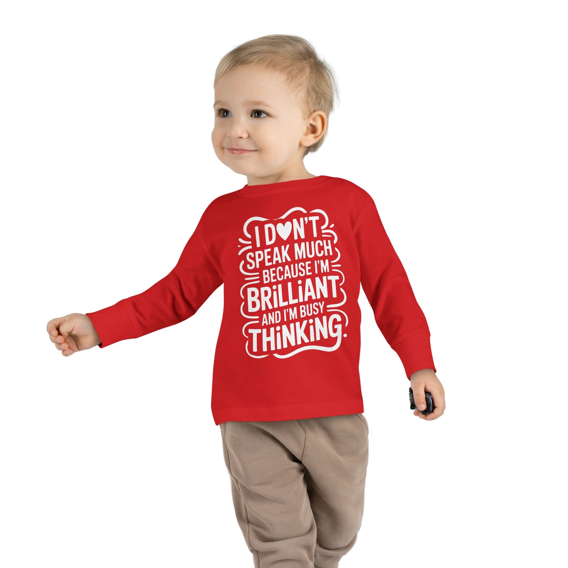 Toddler walking in red autism awareness long sleeve shirt with “I don’t speak much because I’m brilliant and I’m busy thinking” text, side pose.