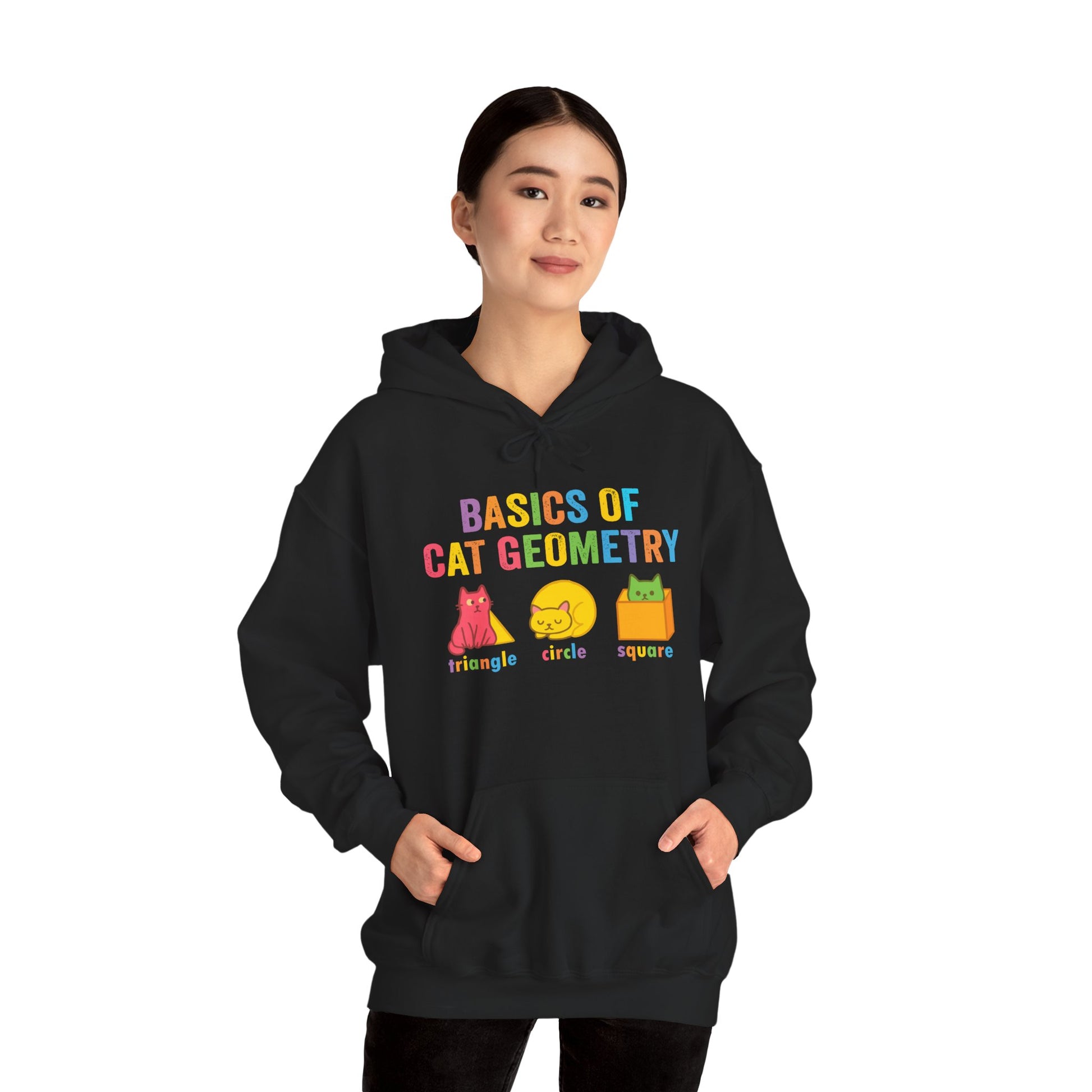 Female model wearing black cat geometry hoodie, standing hands in pockets, showcasing colorful math-themed print for teachers and students.