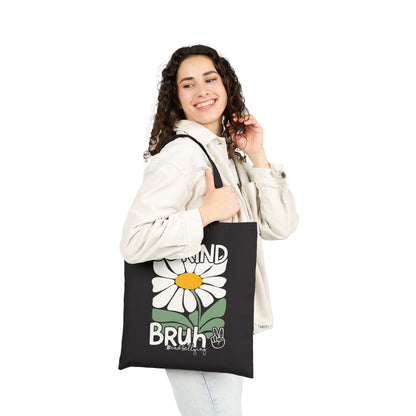 “Female model holding black canvas tote showing Be Kind Bruh daisy and peace sign”