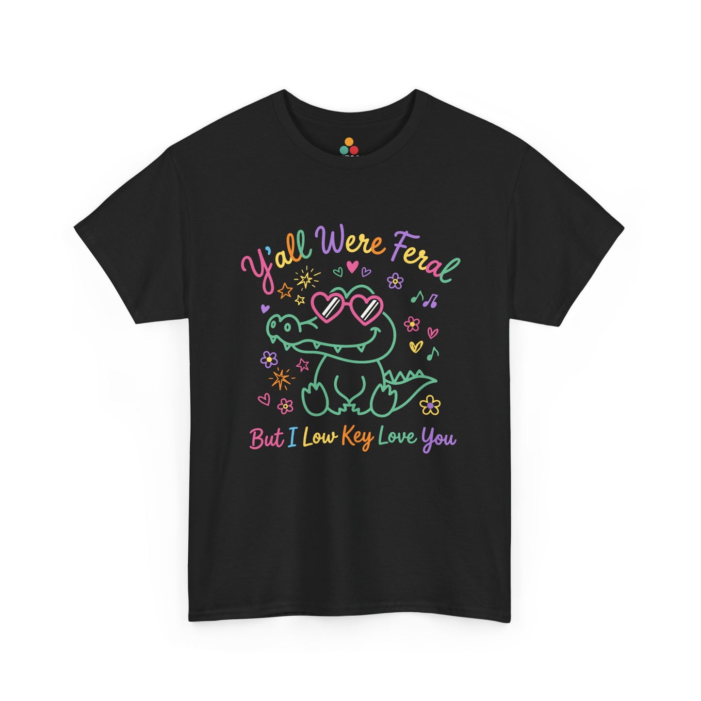 black  T-shirt featuring a cute neon crocodile wearing heart-shaped sunglasses surrounded by colorful stars and flowers, with rainbow text reading "Y'all Were Feral But I Low Key Love You" — a funny last day of school teacher gift shirt.


