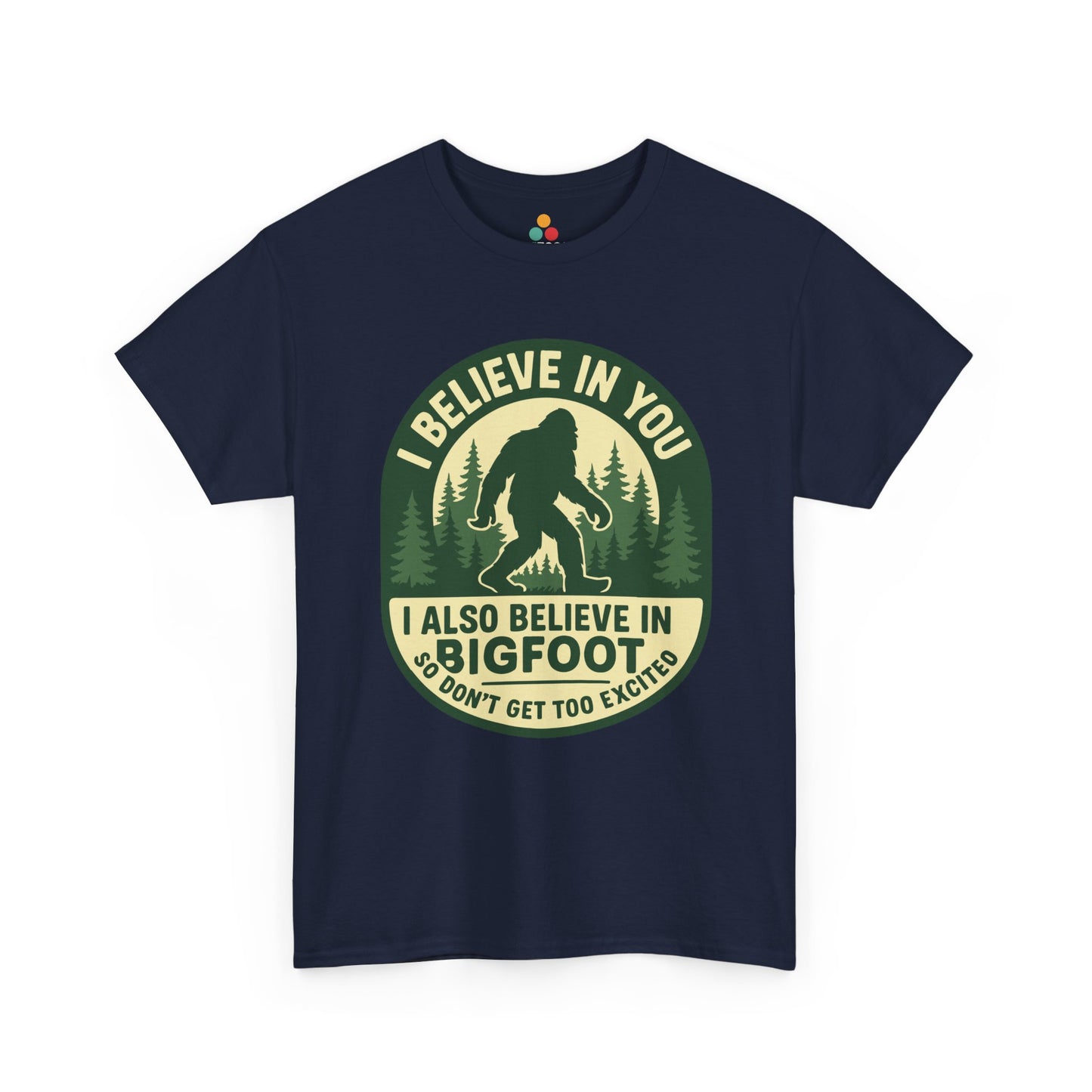  “Teezoca navy blue cryptid tee, I Believe In You I Also Believe In Bigfoot, pine trees, front view”

