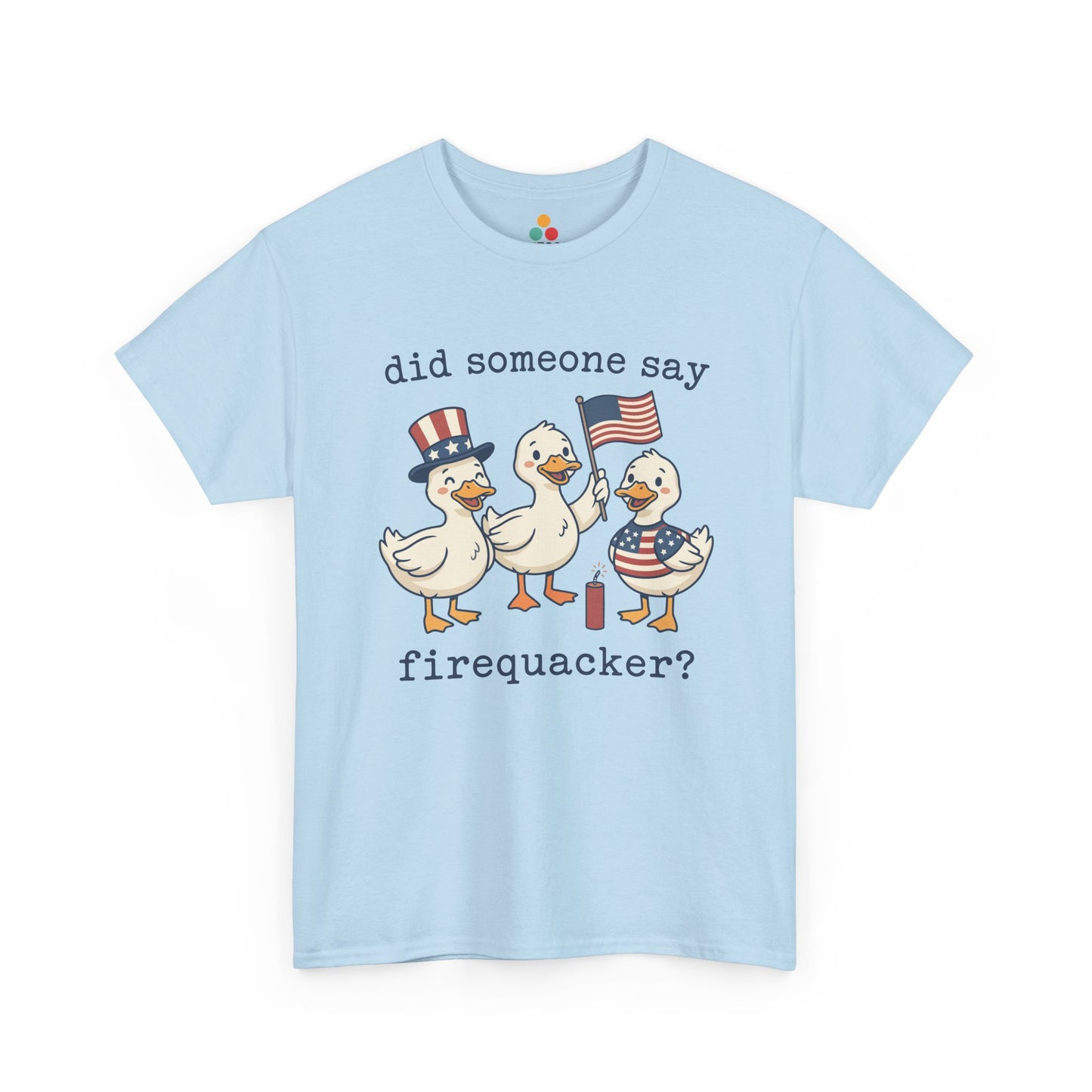 light blue TEEZOCA T-shirt featuring three cartoon patriotic ducks — one in an Uncle Sam hat, one holding a US flag, and one in a stars-and-stripes outfit — around a firecracker with the text "did someone say firequacker?" printed above and below.

