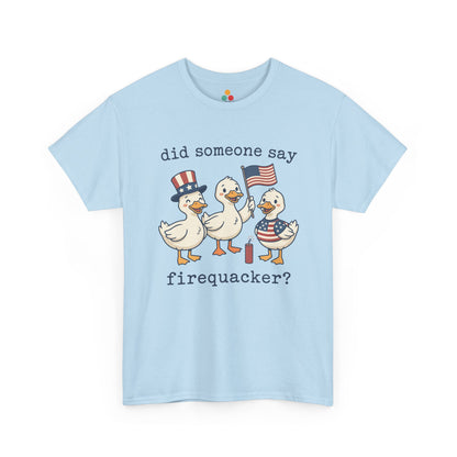 light blue TEEZOCA T-shirt featuring three cartoon patriotic ducks — one in an Uncle Sam hat, one holding a US flag, and one in a stars-and-stripes outfit — around a firecracker with the text "did someone say firequacker?" printed above and below.

