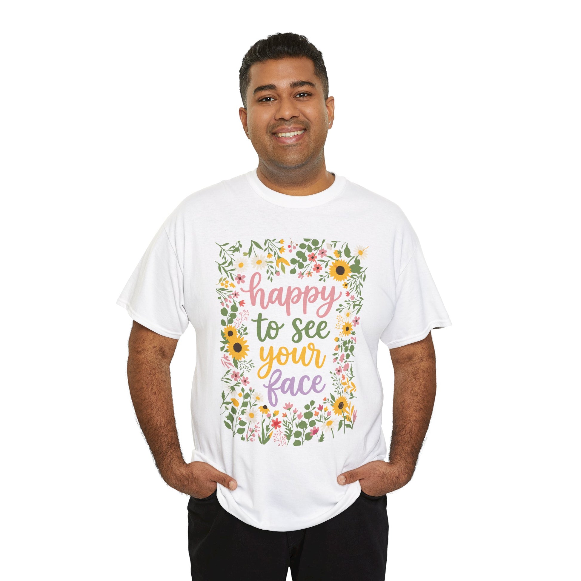 men wearing a White T-shirt featuring the phrase “Happy to See Your Face” in pastel lettering framed by a floral border with sunflowers and wildflowers.

