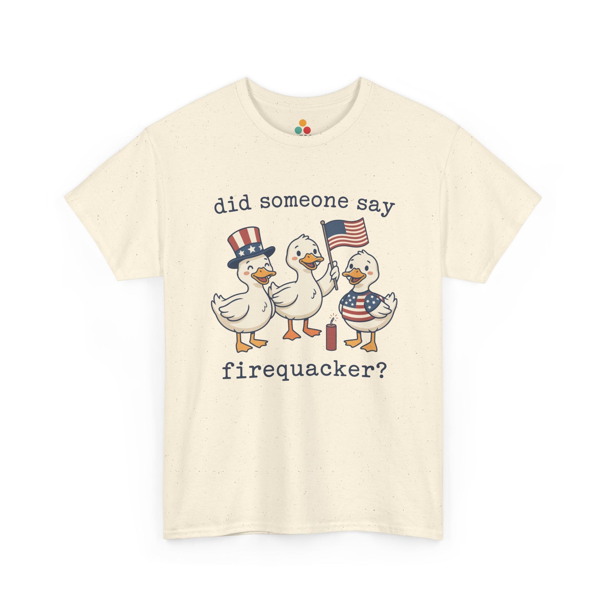 sand beige  TEEZOCA T-shirt featuring three cartoon patriotic ducks — one in an Uncle Sam hat, one holding a US flag, and one in a stars-and-stripes outfit — around a firecracker with the text "did someone say firequacker?" printed above and below.

