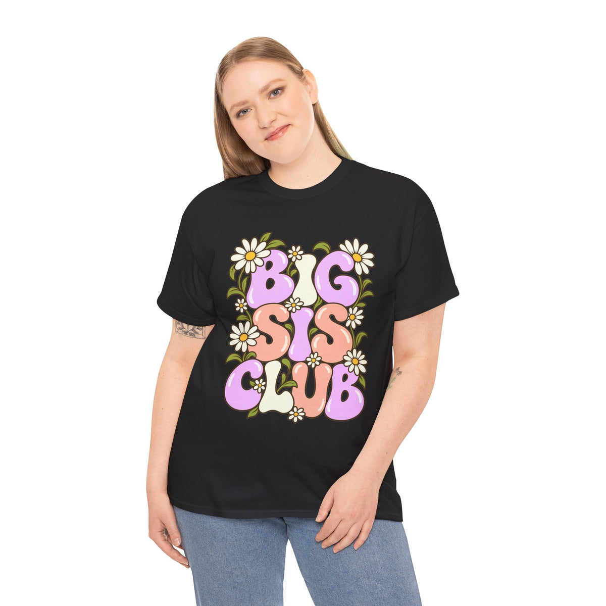 Woman wearing a black Big Sis Club T-shirt with pastel retro lettering and daisy artwork